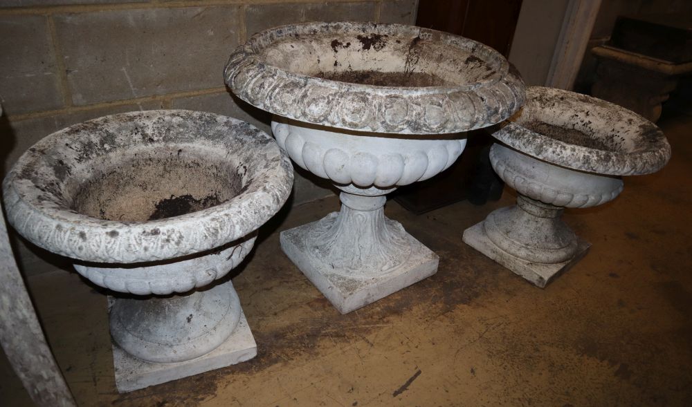 Three reconstituted stone campana garden urns, largest 70cm diameter, H.62cm